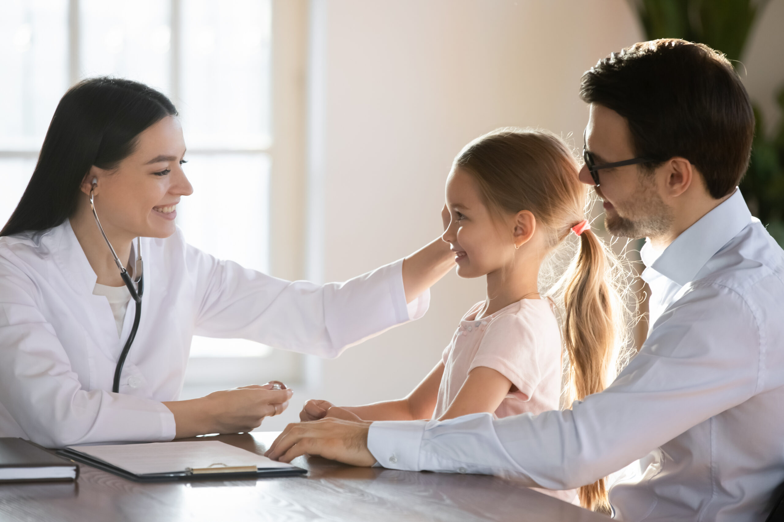 Smiling,Pleasant,Female,Pediatrician,Stroking,Head,Of,Preschool,Girl,Sitting